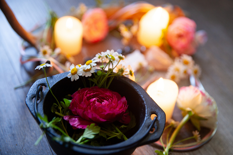 image is a photograph of a pagan wedding altar with a flower and candle and other beautiful objects