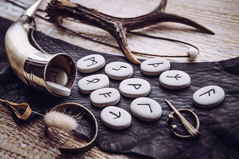 Photo shows Norse runes and a ceremonial Viking horn, with other tools for witchcraft and Pagan spell casting