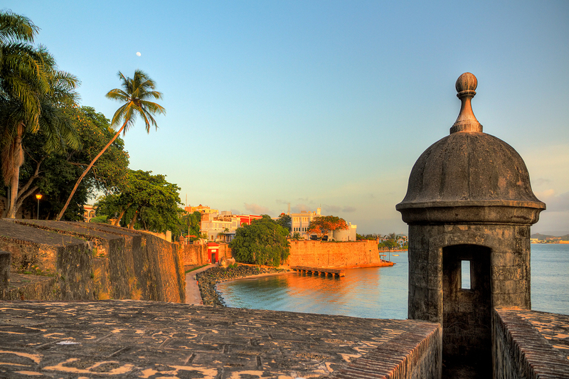 A photo of San Juan, the coast line lit up by warm orange light at sunset 