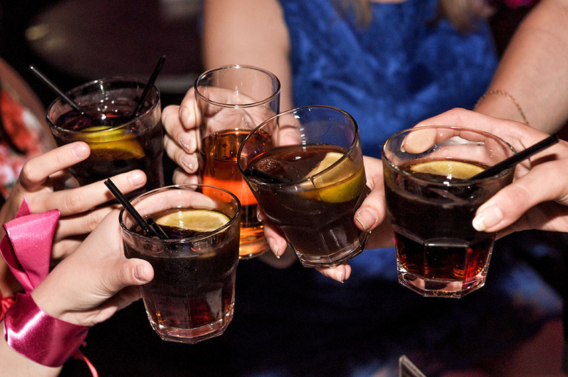 Close up photo of friends clinking glasses during a wedding reception 