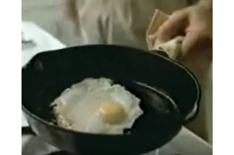 A still image from the 1980s anti-drug PSA, "this is your brain on drugs", showing an egg frying in a pan