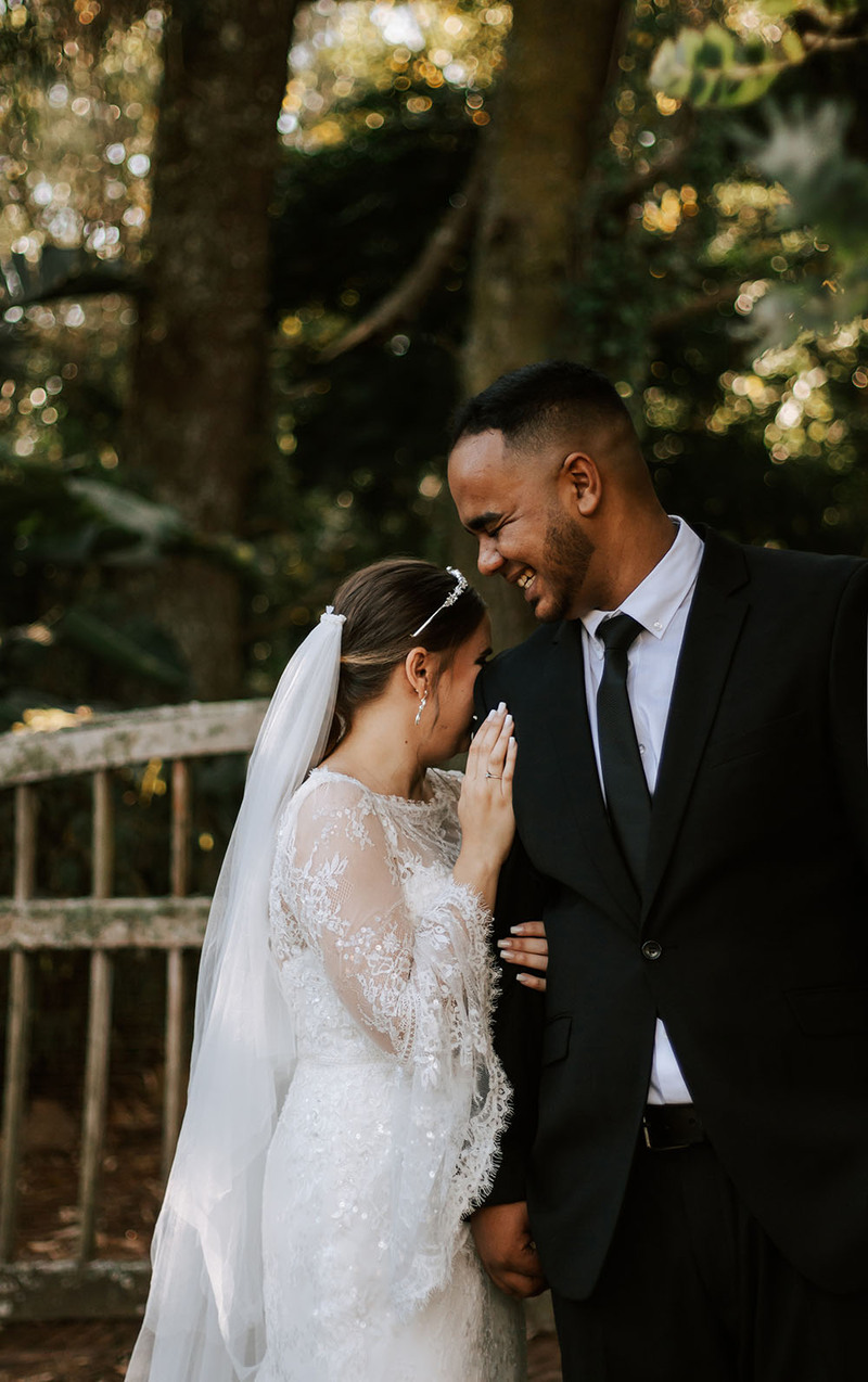 Happy newlyweds laugh and embrace outdoors on the wedding day