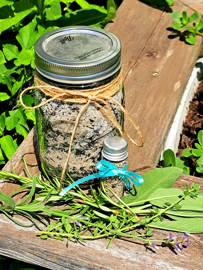 Photo of a jar with a ribbon that contains witches black salt, a love smudge blend with salt and the ashes of sacred herbs and sage, sitting outside in the sun