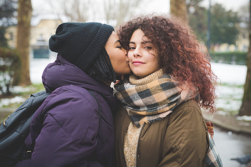 A young couple kiss outdoors 