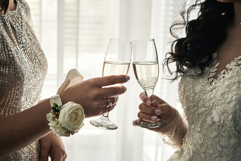 Close up of two brides toasting with champagne on their wedding day