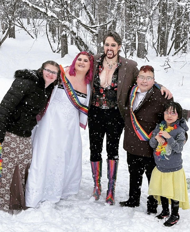 Officiant & Performer Hank VanDickerson stands with newlyweds and their family outside in the snow following a wedding ceremony