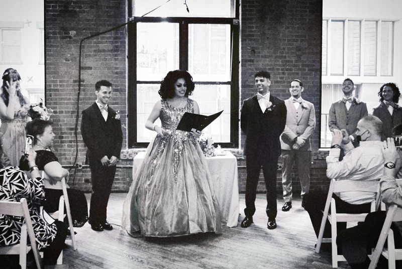 Pixie Ventura officiates a wedding, reading from the wedding ceremony script as guests smile happily