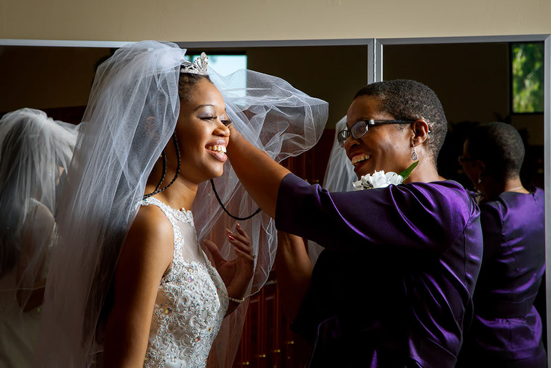 A woman helps the bride with her wedding veil