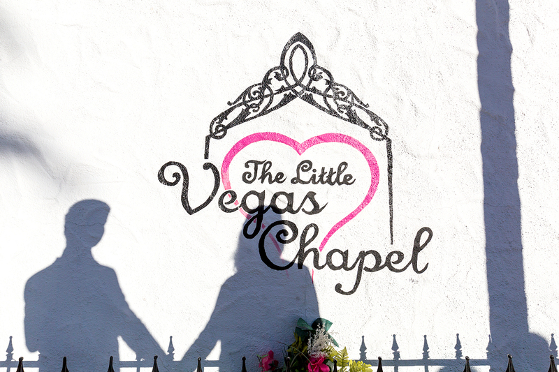 Shadow of a couple holding hands against the Little Vegas Chapel wall