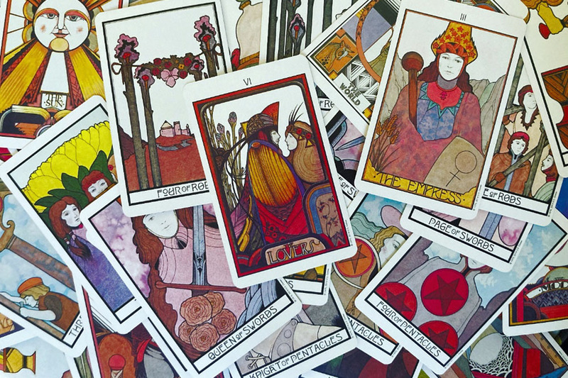 PHOTO OF COLORFUL TAROT CARDS SPREAD OUT 