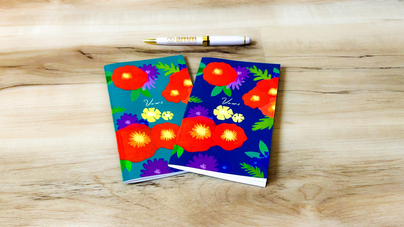 Floral design vow books, with brightly colored flowers on the front