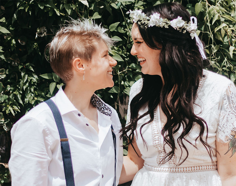 Young newlyweds smile happily at each other on the wedding day