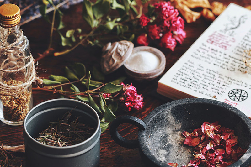 Close up of a Wiccan altar with herbs and candles gathered to create a salt and sage love smudge for a wedding ceremony
