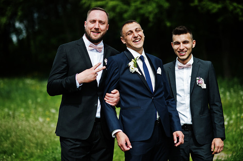 Two friends stand with a groom during his outdoor sologamy ceremony