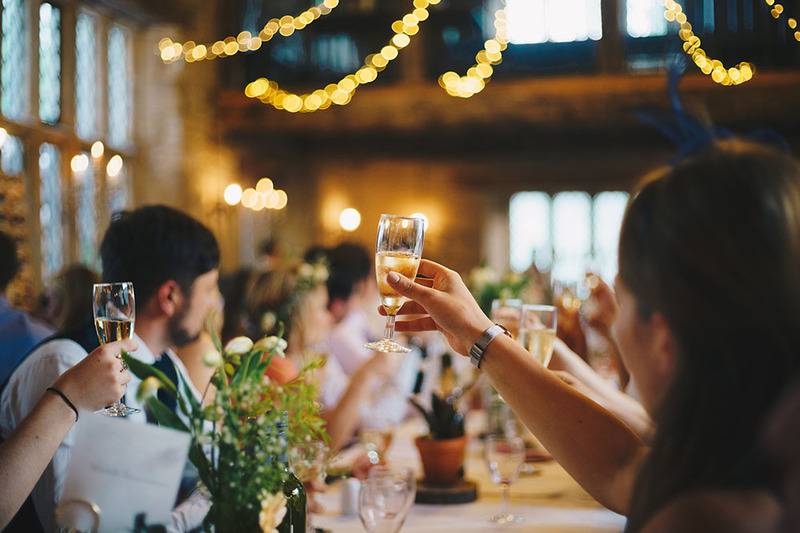 Guests raise glasses of champagne and wine during a wedding toast