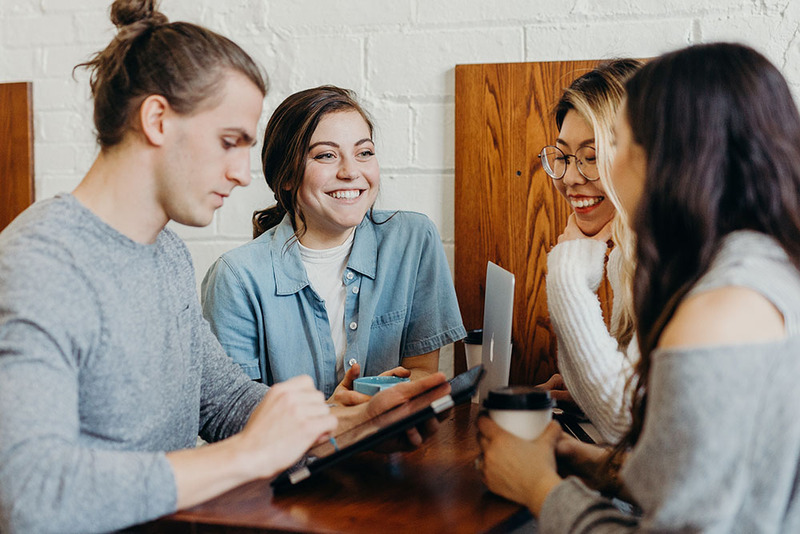 A group of friends chat and catch up over coffee during a wedding professional's convention