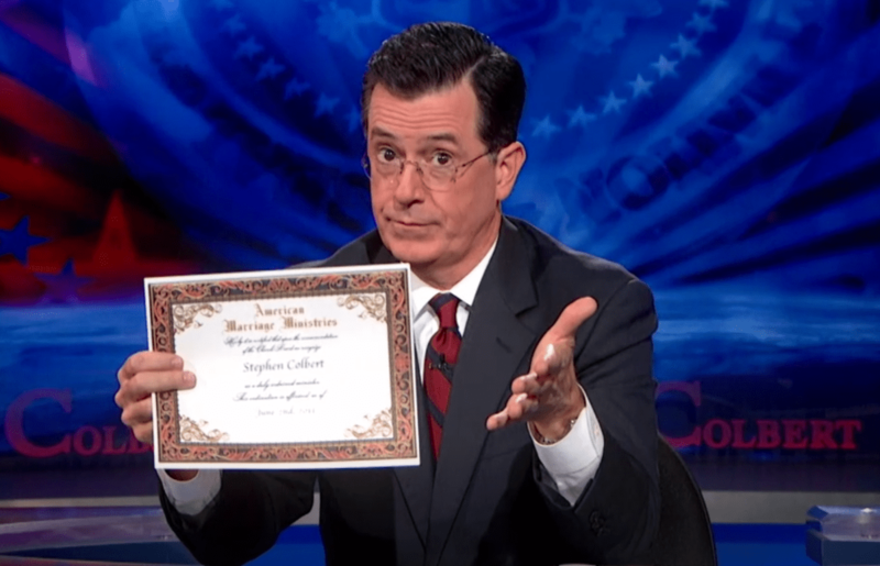 Stephen Colbert holds up a copy of his American Marriage Ministries ordination certificate on the set of his show, before officiating marriages on-air during the government shutdown