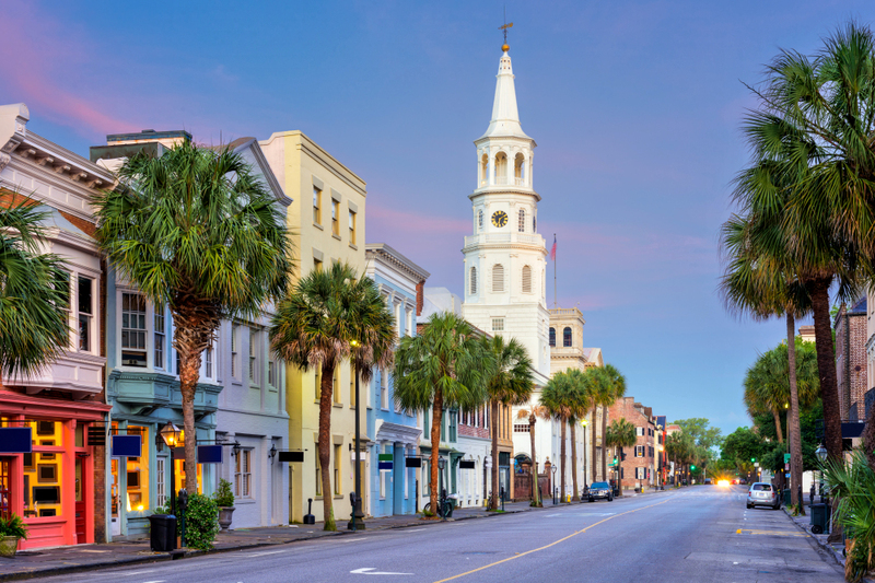 Photo of a vibrant city in South Carolina at sunset, with colorful buildings and palm trees