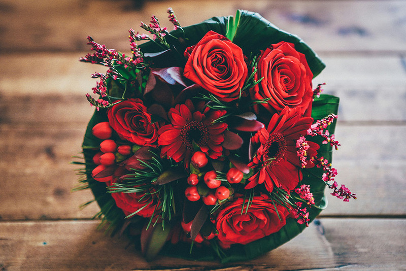 A beautiful wedding flower bouquet of red roses and greenery