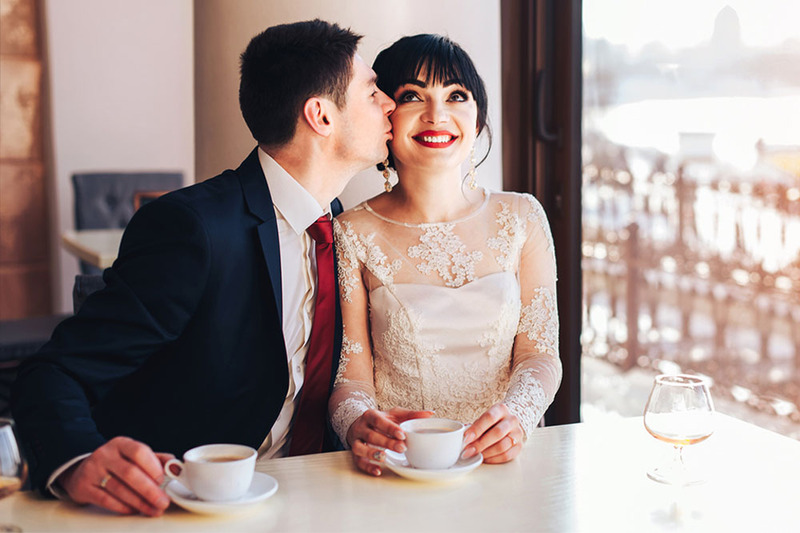 Newlyweds on the wedding day drinking cups of coffee to stay sober at their ceremony