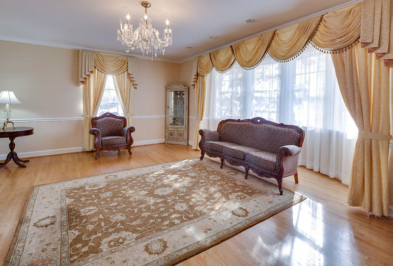Marshall-March Funeral Homes interior photo showing an elegant sitting room with luxurious curtains, chair, and loveseat