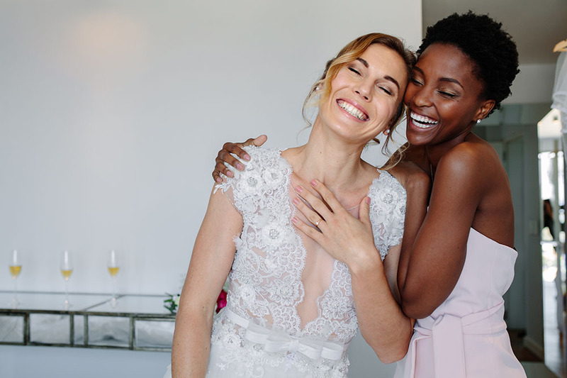 Two friends embrace on the wedding day, the bride and her wedding officiant friend