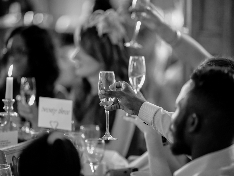 Guests raise their glasses during a wedding toast. 