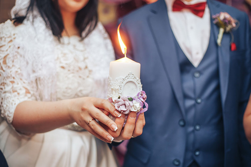 Close up of a bride and groom during their unity candle ceremony 