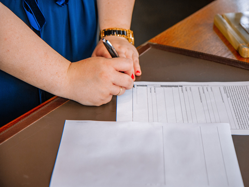 A wedding officiant completes the marriage license.