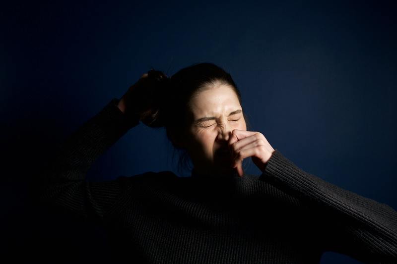 a photo of a woman sneezing