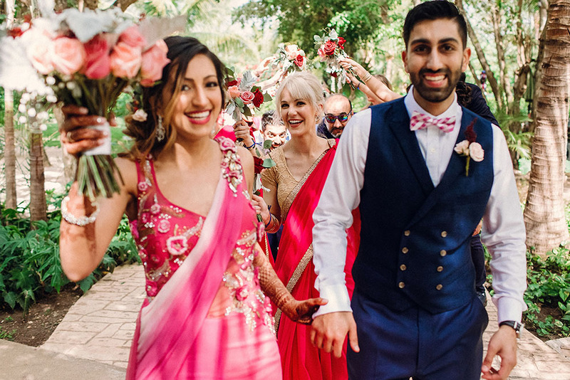 Indian bride and groom pose happily with guests on the wedding day