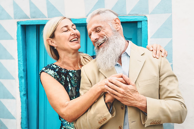 An older couple embrace happily on their vow renewal ceremony day.