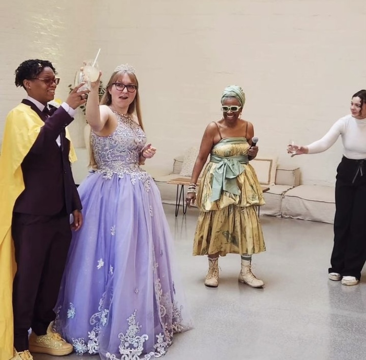 Brides Beka and Laura hold up their drinks to toast their new marriage as friends and family watch