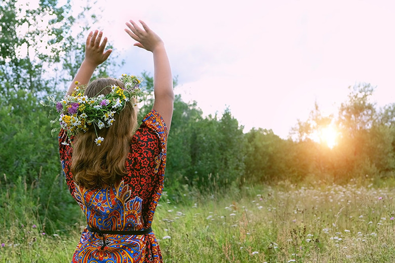 A young woman holds her hands up in the air to call the corners during a Wiccan wedding ceremony