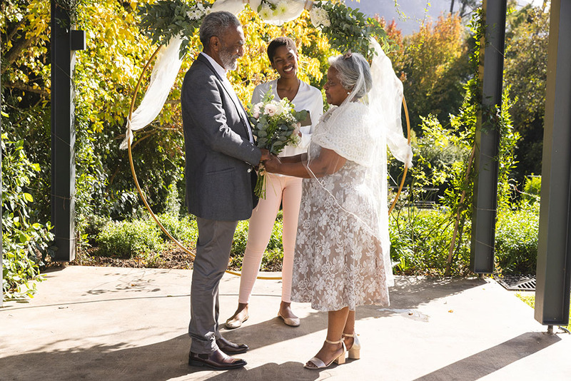 A young wedding officiant performs a ceremony outdoors for her parents