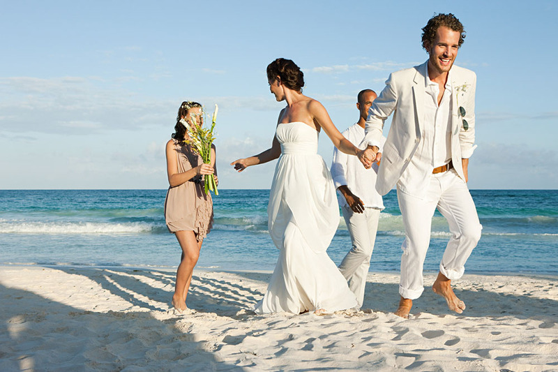 Bride and groom on the beach with friends and family for their wedding