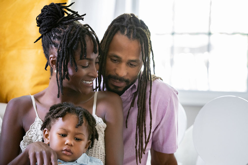 Young African American couple with child, newlyweds, smiling and looking happy