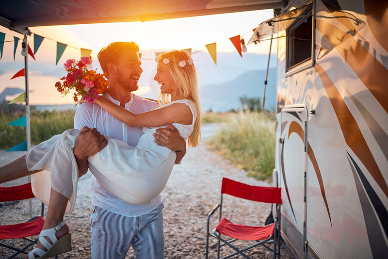 Newlyweds outside an RV during a roadtrip wedding