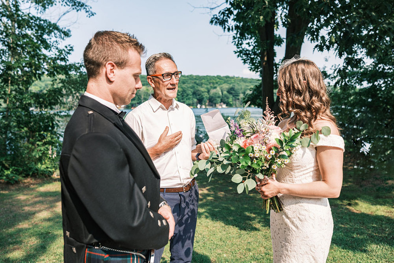A wedding officiant performs an outdoor wedding ceremony for a bride and groom