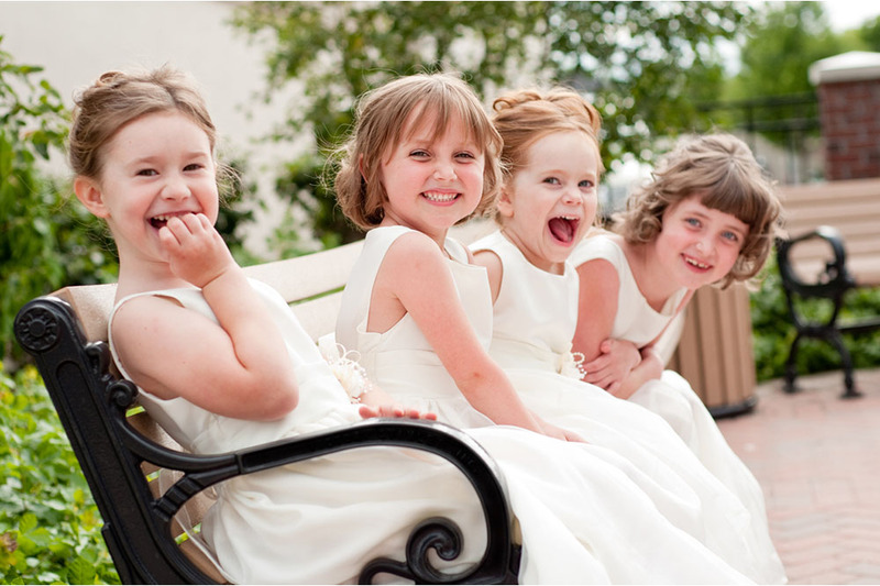 Smiling young girls dressed in formal wear at a wedding ceremony, flower girls
