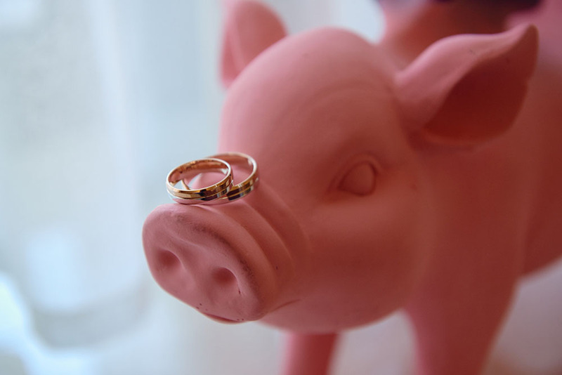 Close up of a pig figurine with wedding rings on its nose