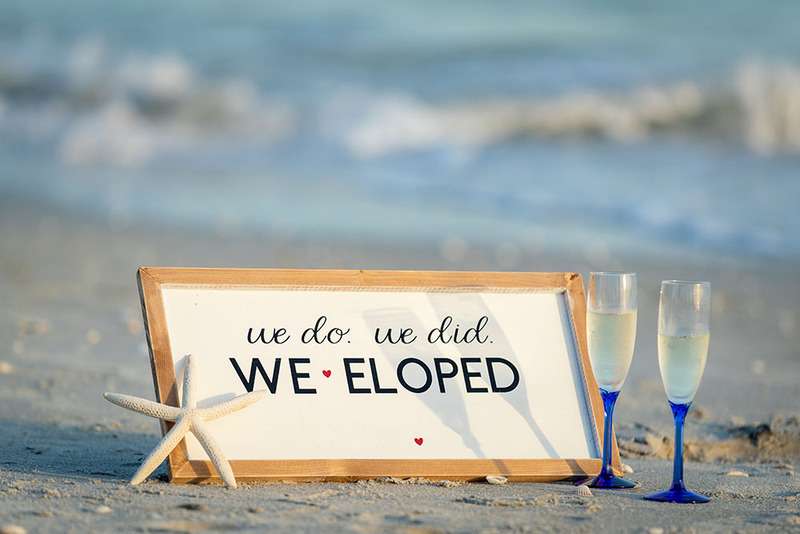 Sign on the beach that says: "We do. We did. We eloped"