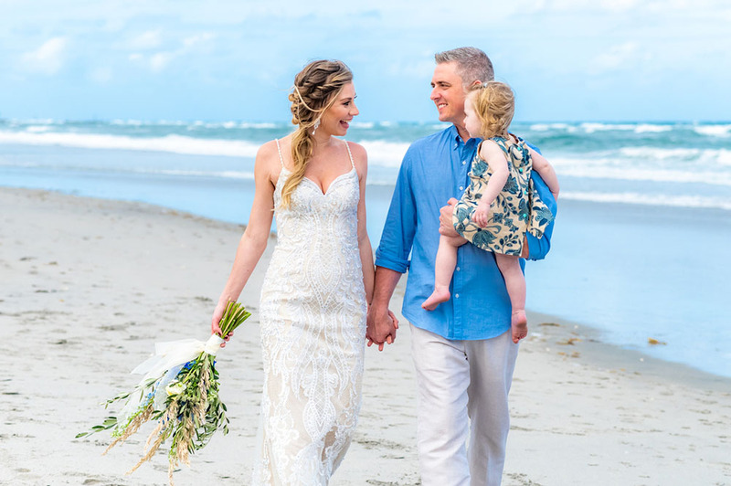 Bride and groom eloping with young child on the beach