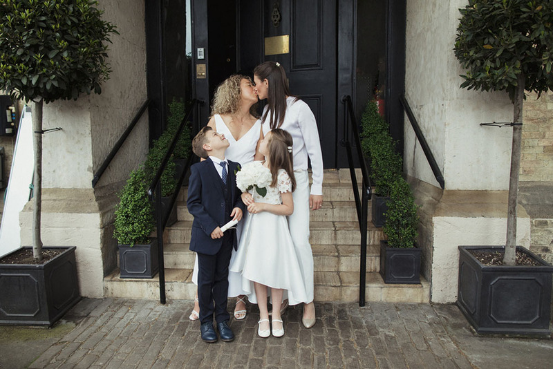 A happy lesbian couple with their two kids during their elopement ceremony