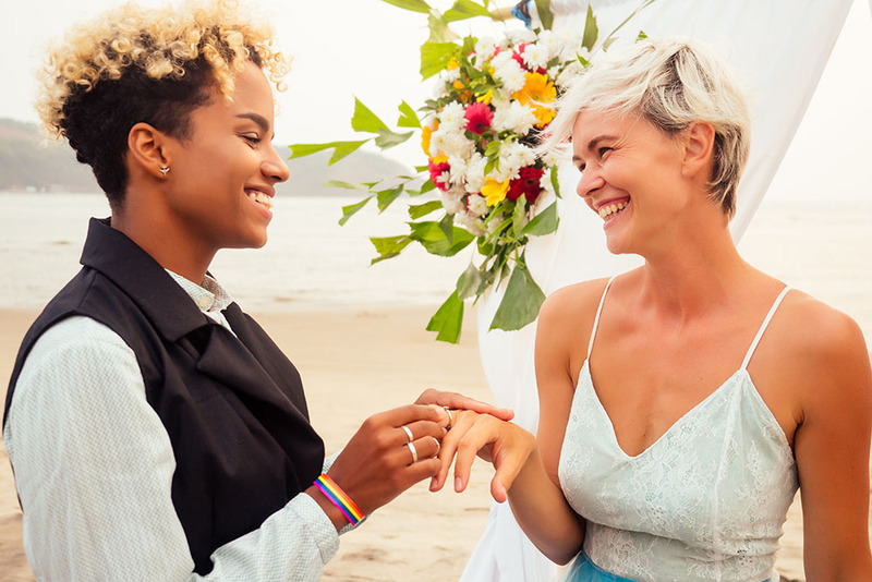 Two brides exchange rings on the wedding day