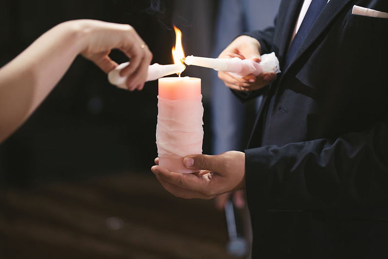  Close up bride and groom lighting the unity candle during the wedding unity ceremony