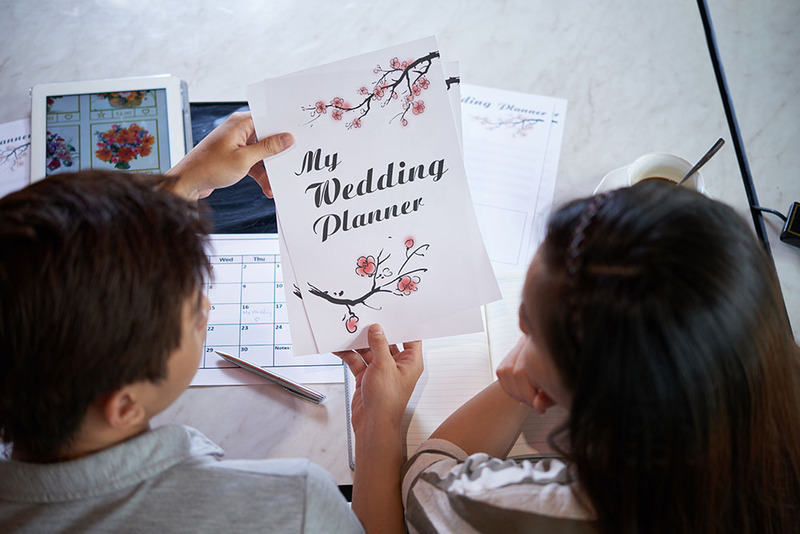 Close up of a bride and groom looking at a wedding planning checklist