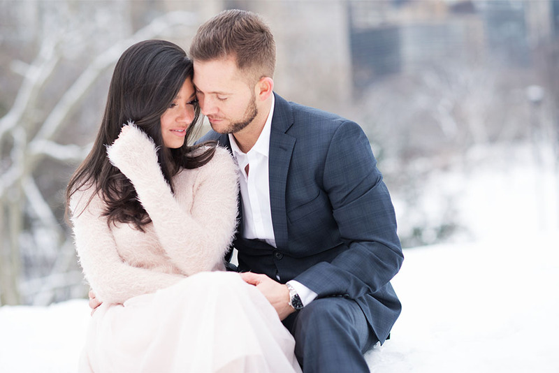 Engaged couple pose in the snow 