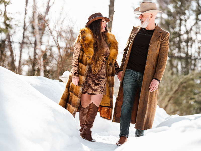Older couple engaged, holding hands and walking in the snow 