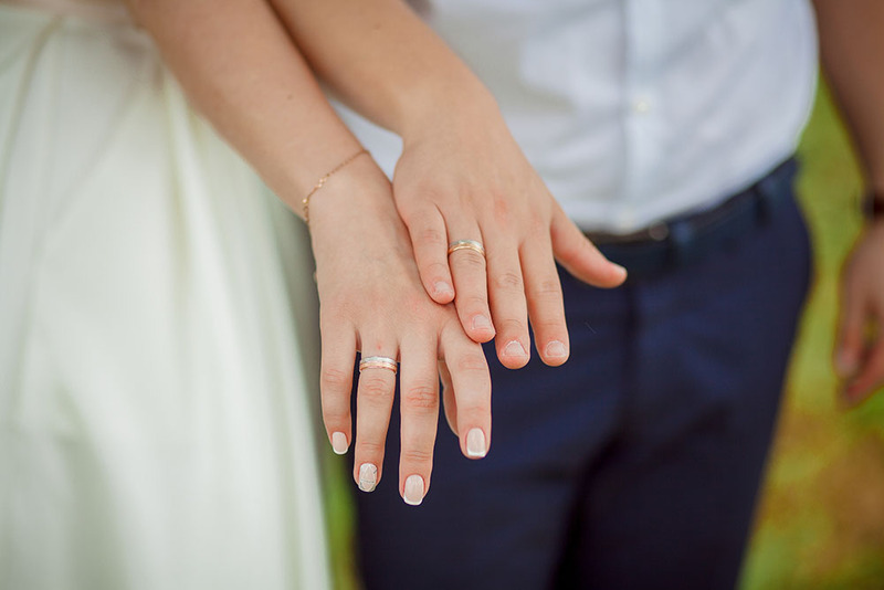Close up of bride and groom showing off their wedding rings